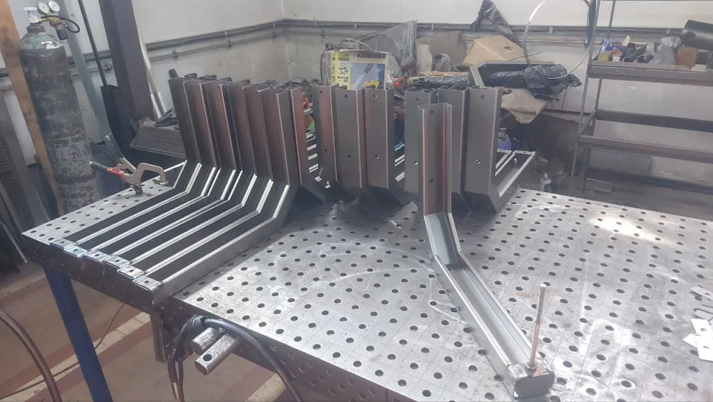 Зварювальний стіл із металевими деталями у майстерні