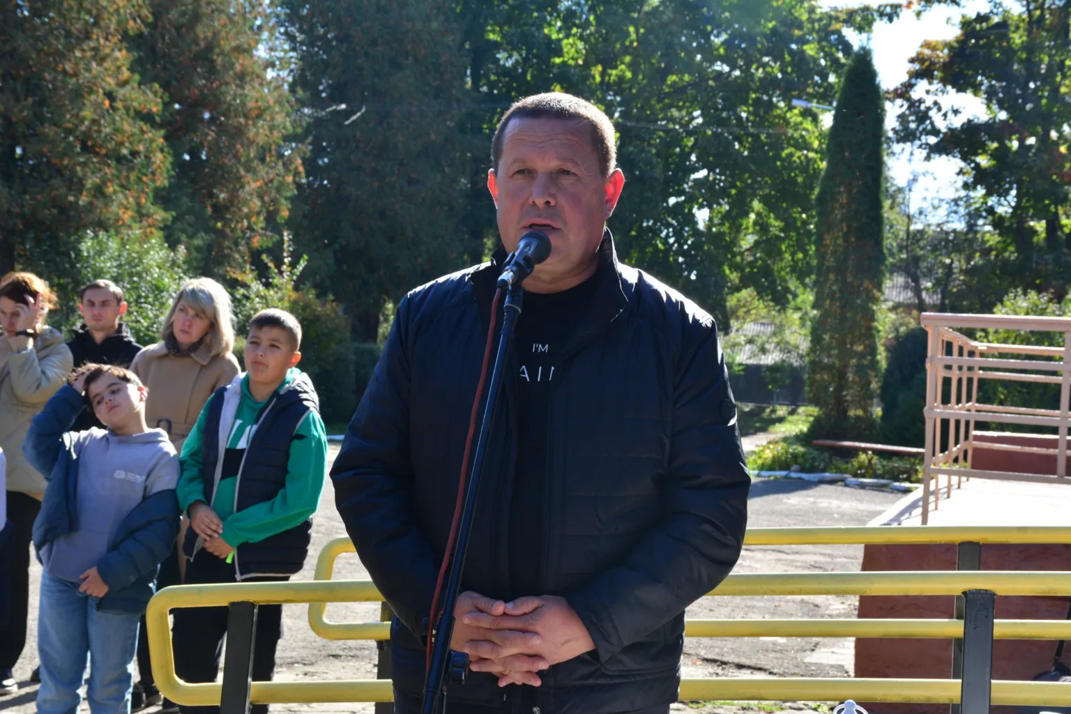 Чоловік виступає на вулиці перед мікрофоном