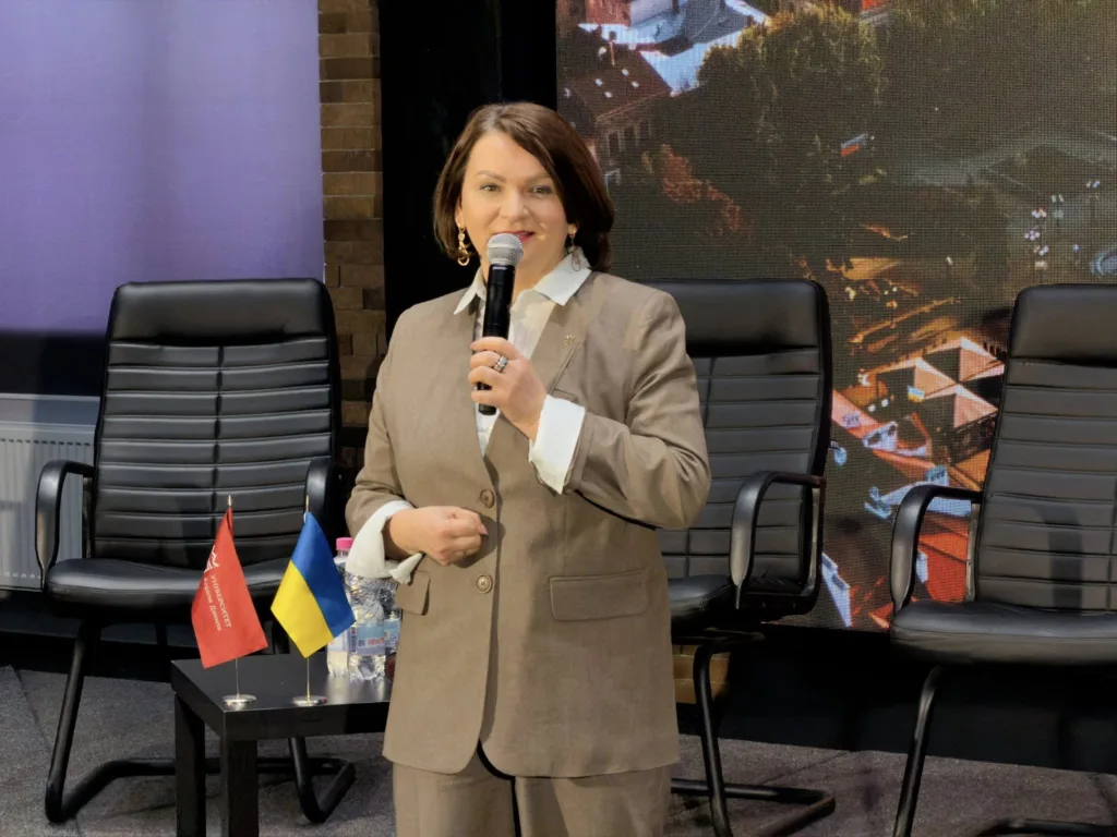 Жінка виступає з мікрофоном на конференції