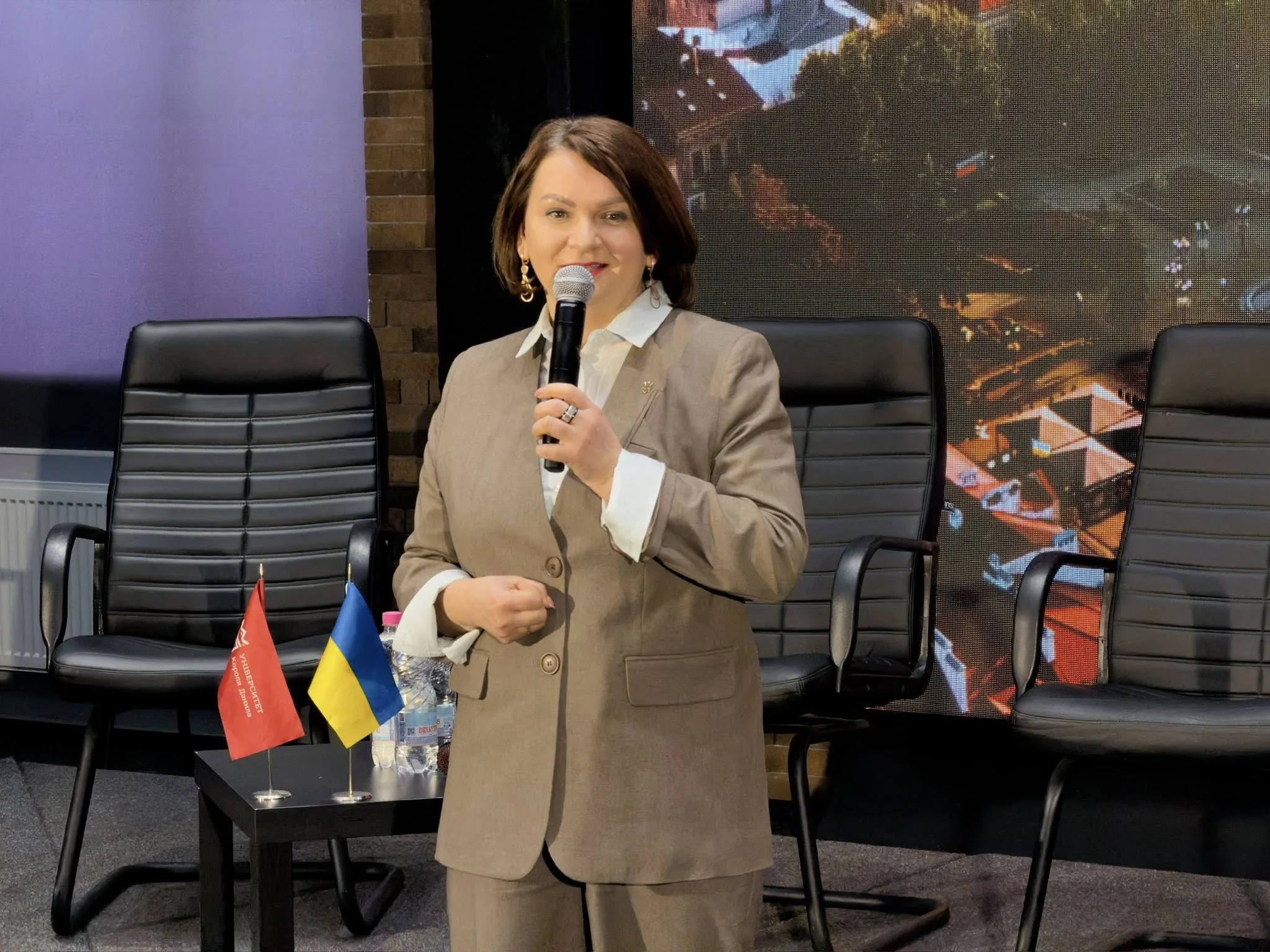 Жінка виступає з мікрофоном на конференції