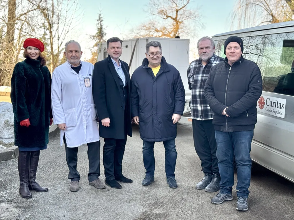 Група людей поруч з автомобілем Caritas Czech Republic