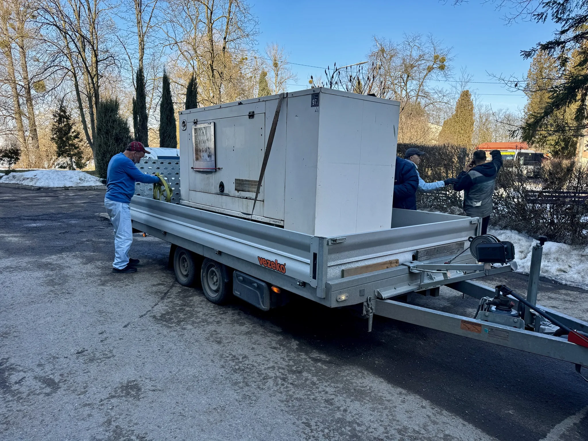 Люди завантажують обладнання на причіп взимку