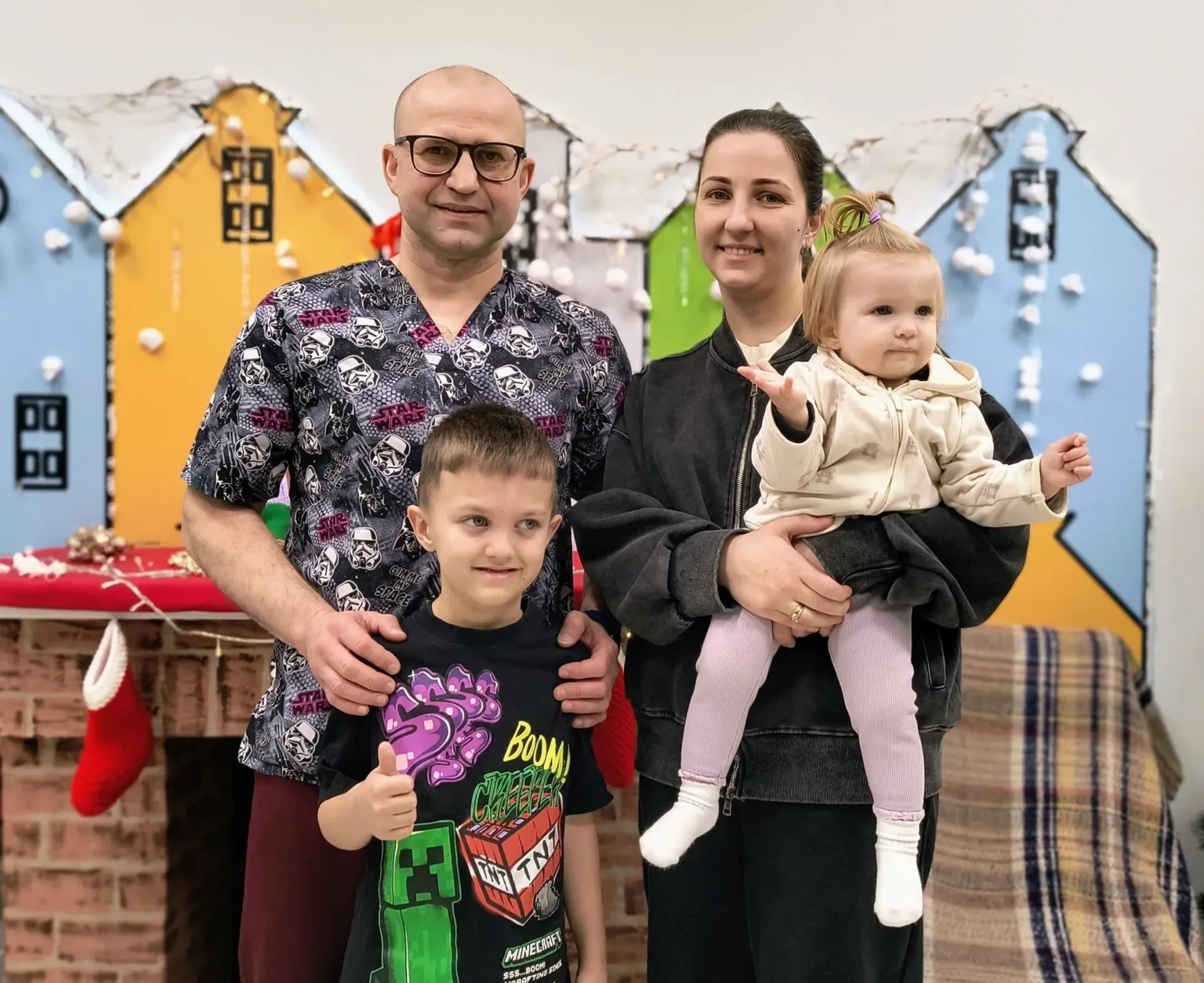 Щаслива родина позує перед різнокольоровим фоном