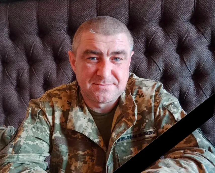 Військовий у камуфляжі сидить на фоні дивана