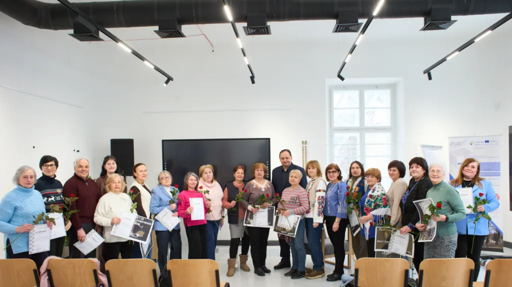 Групове фото учасників із сертифікатами та квітами