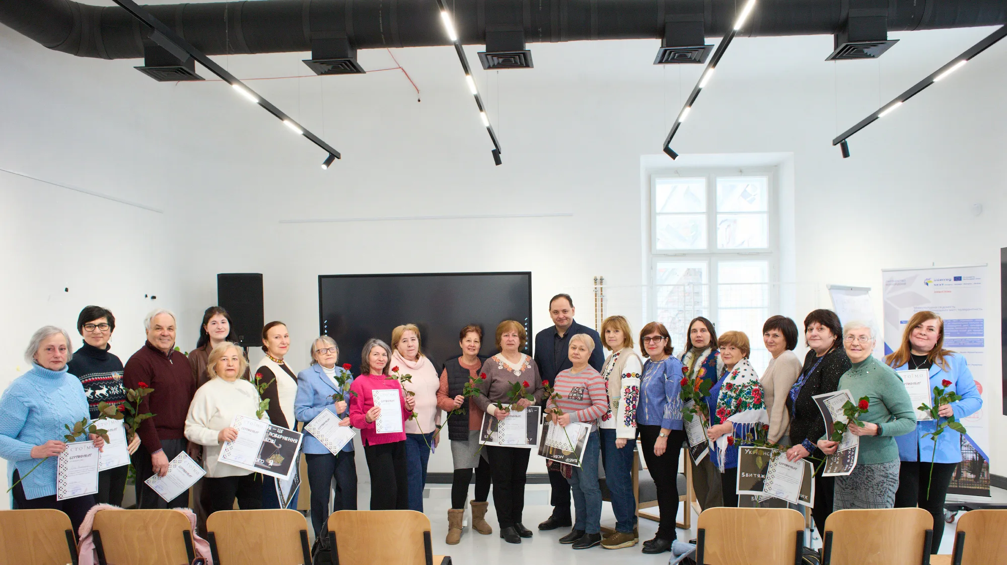 Групове фото учасників із сертифікатами та квітами