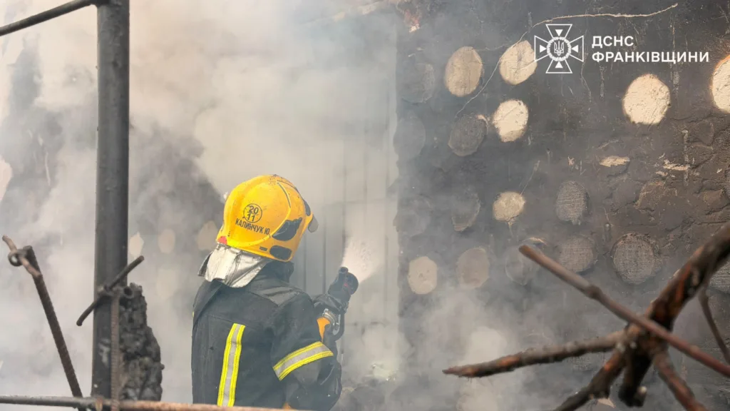 Пожежник гасить будинок, охоплений димом