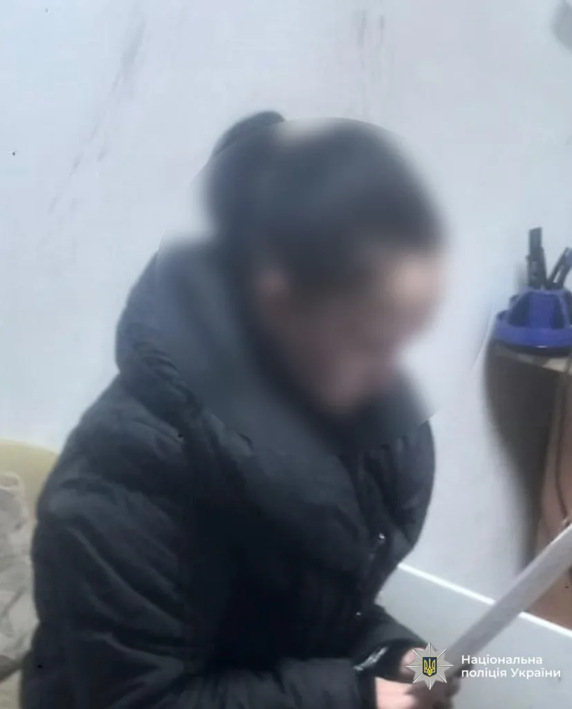 Людина у чорній куртці тримає документ