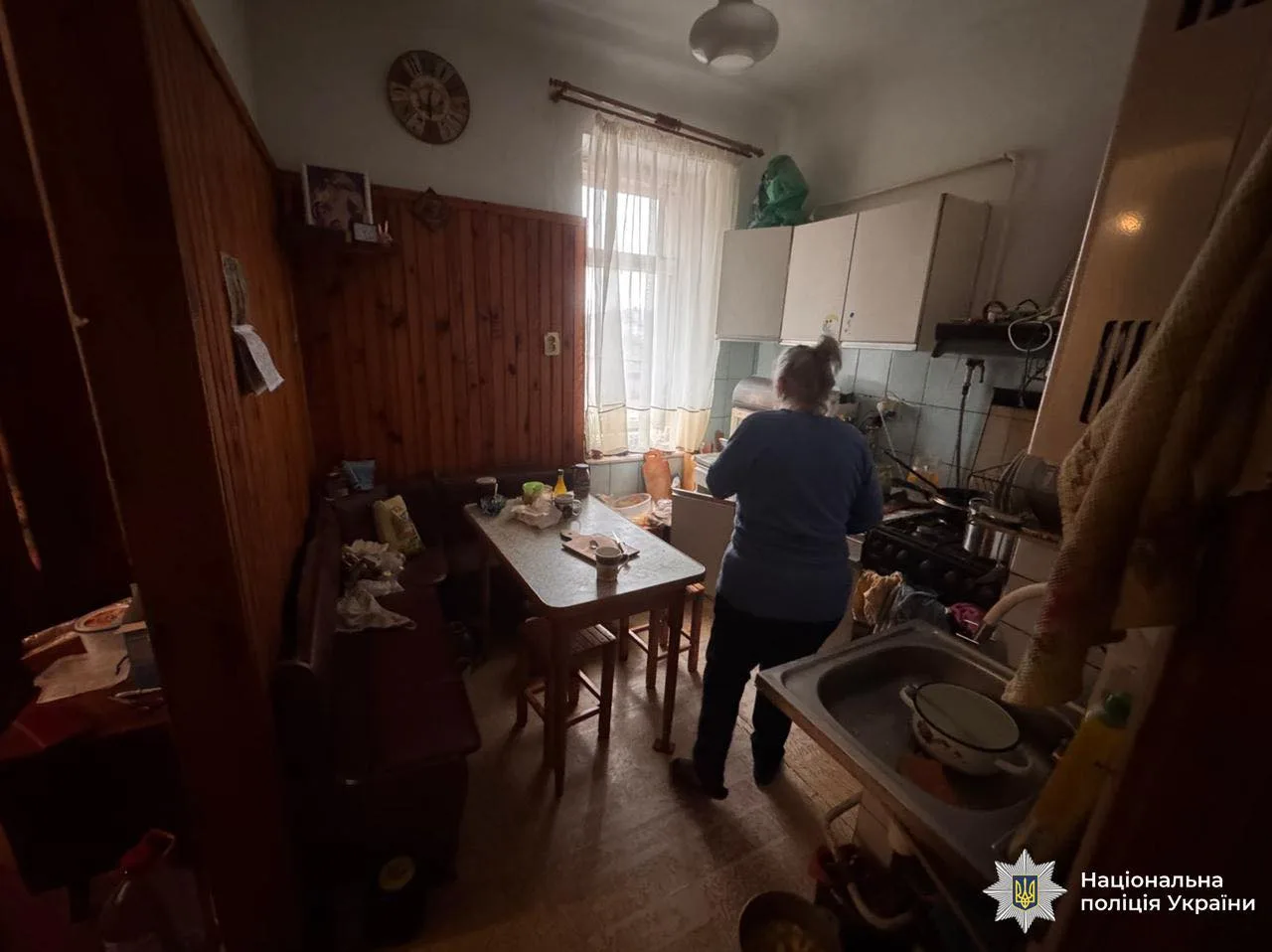 Жінка на кухні готує їжу біля плити