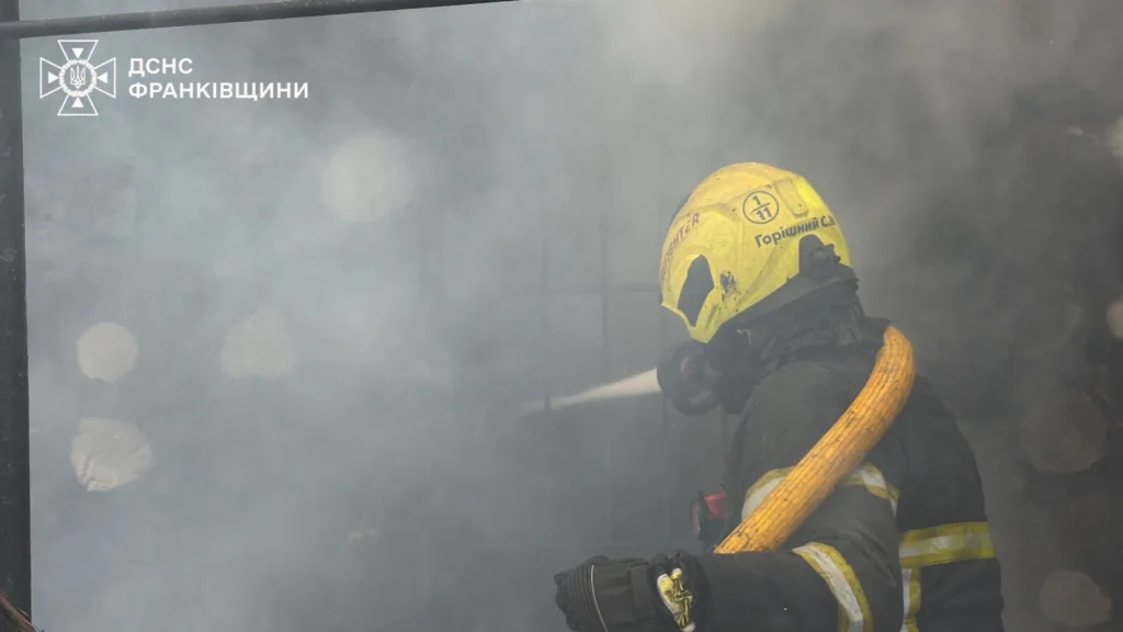 Пожежник гасить вогонь у диму