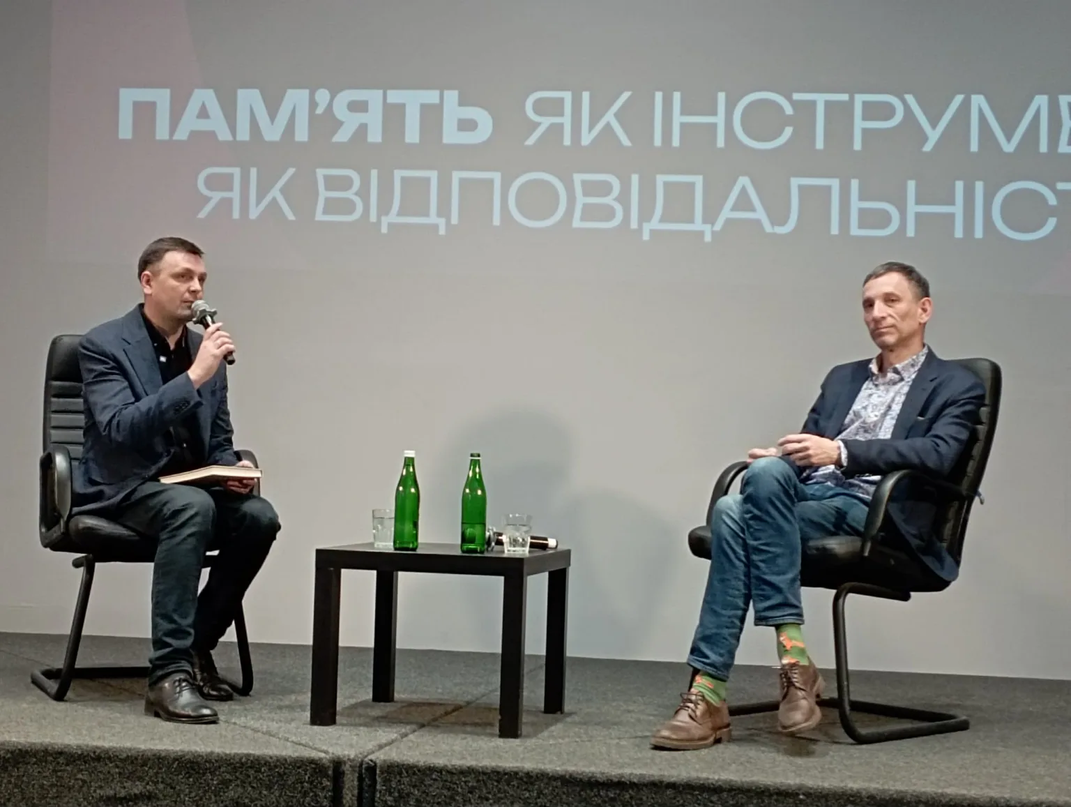 Двоє чоловіків на сцені під час обговорення