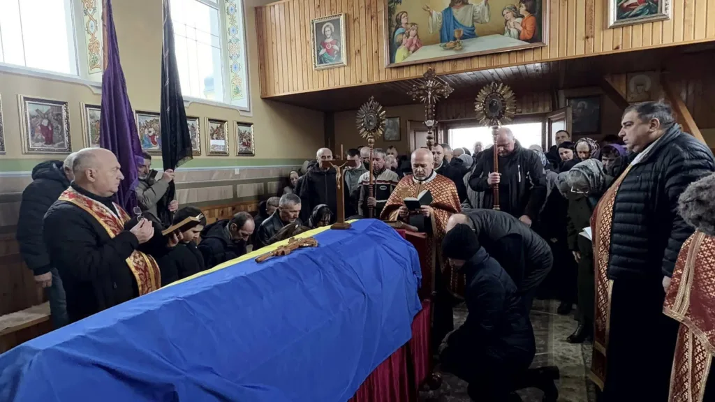 Похоронна служба в церкві з українським прапором