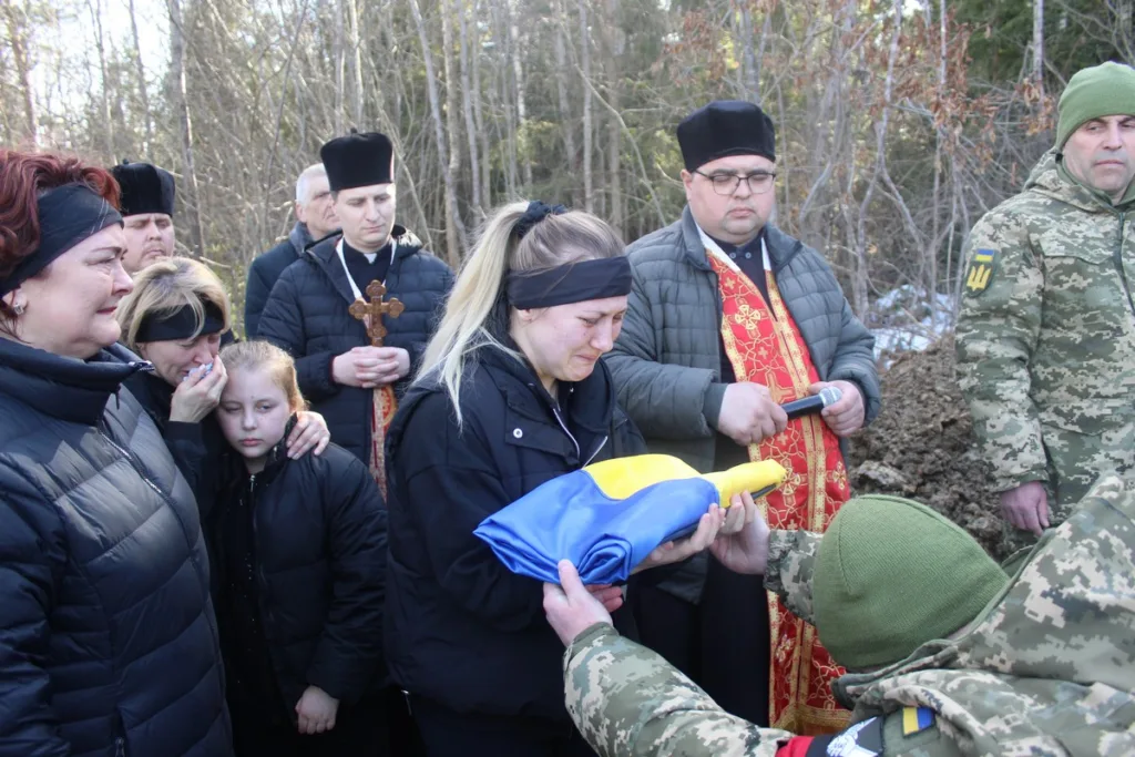Прощання із загиблим військовим, передача українського прапора