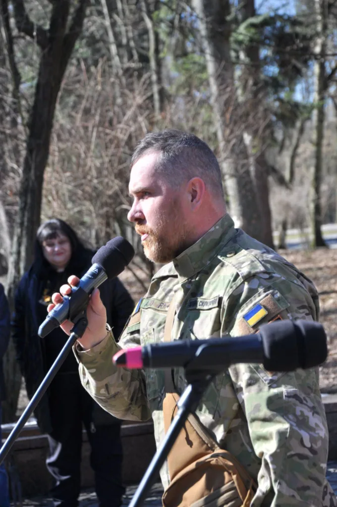 Український військовий говорить у мікрофон на вулиці