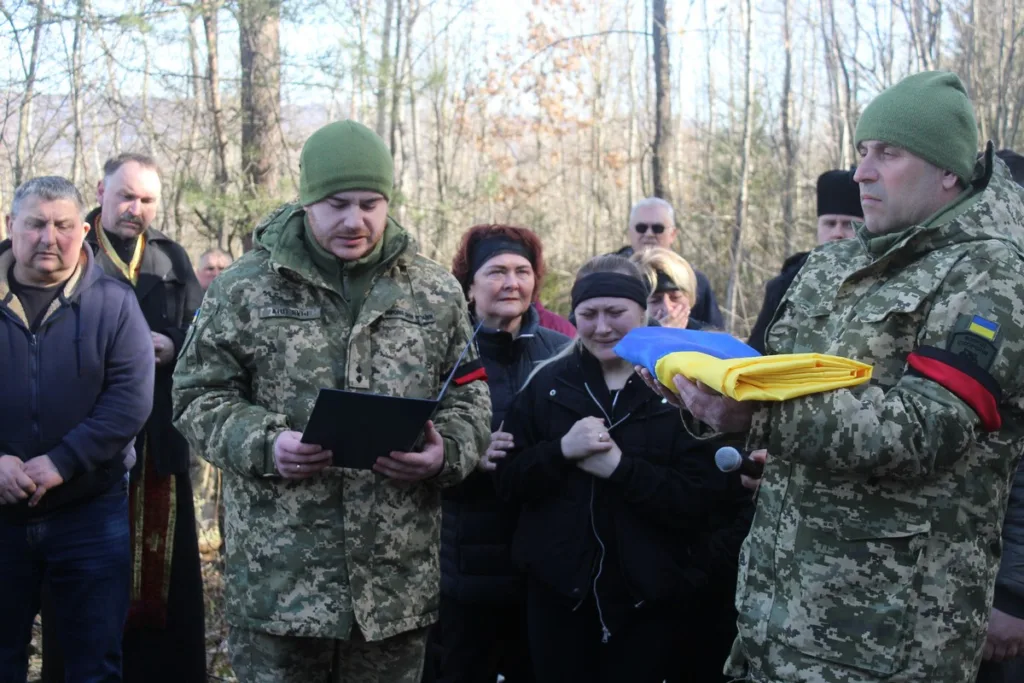 Військові проводять церемонію з українським прапором