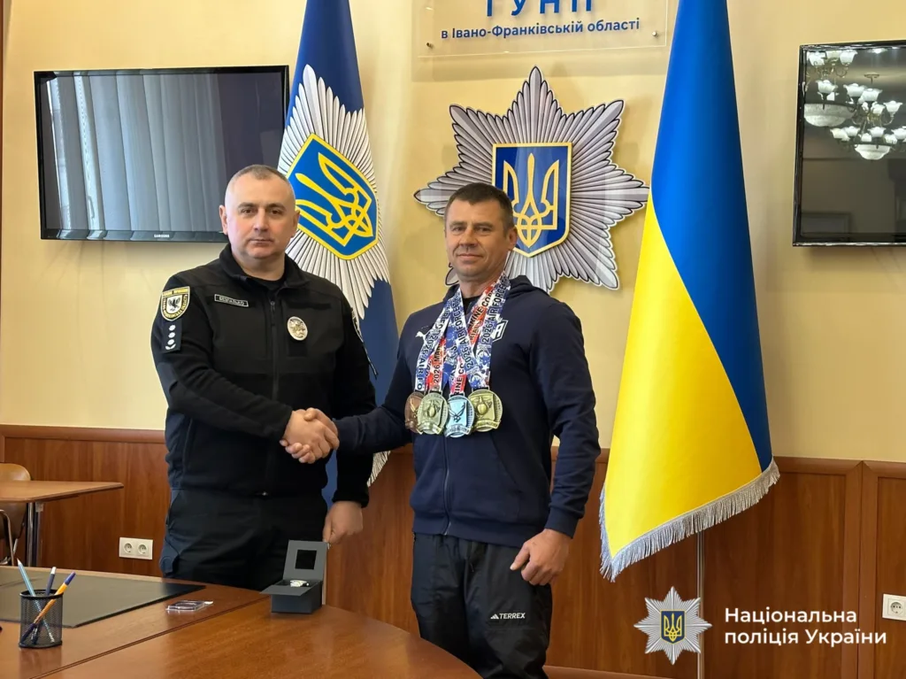 Поліцейський вітає спортсмена з медалями в Івано-Франківську
