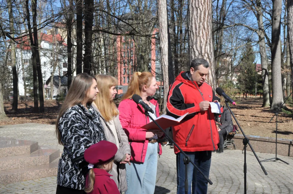 Люди виступають біля мікрофонів у парку