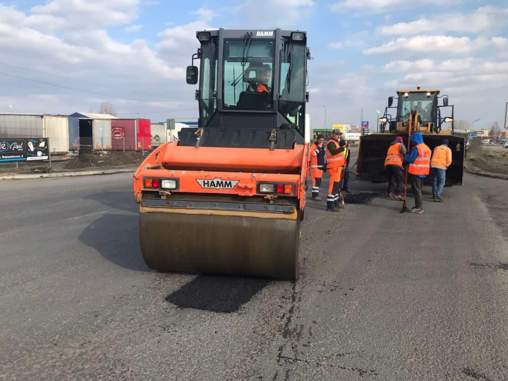 Робітники ремонтують дорогу асфальтоукладальником