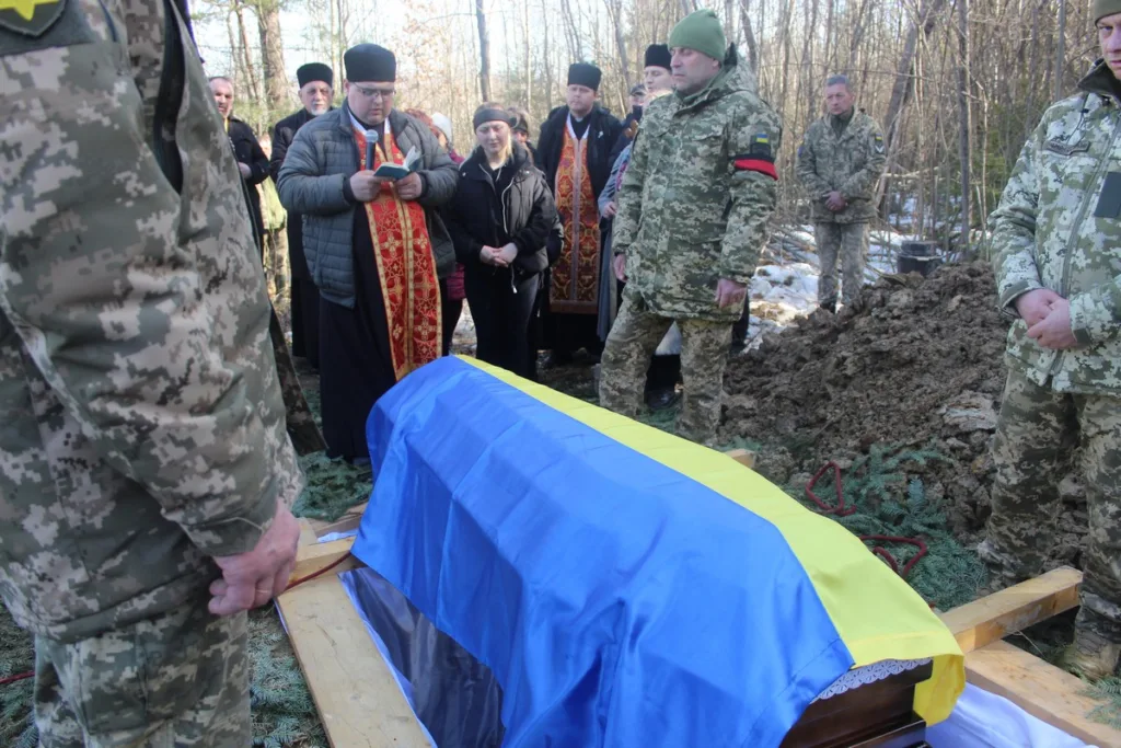 Поховання військового з українським прапором