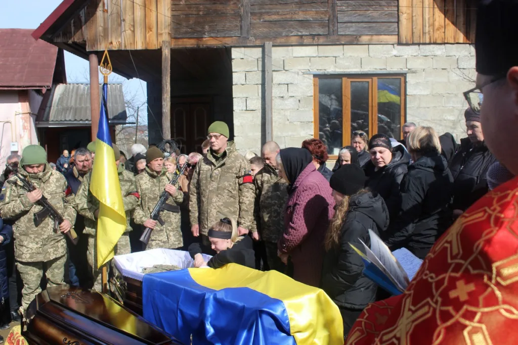 Похорон загиблого військового з українським прапором