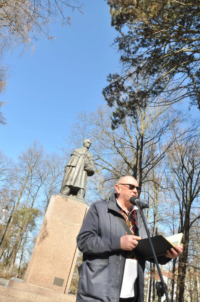 Чоловік читає біля пам’ятника на відкритому повітрі