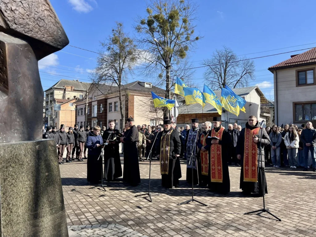 Священники та люди на вуличній церемонії з прапорами