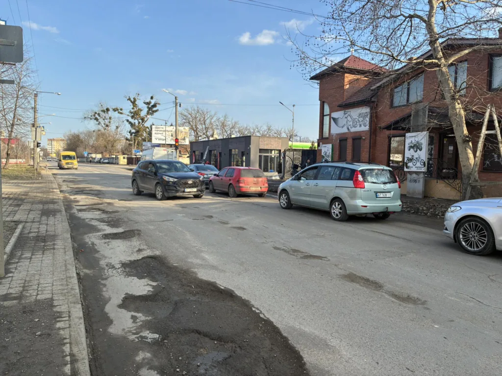 Вулиця з автомобілями біля цегляної будівлі