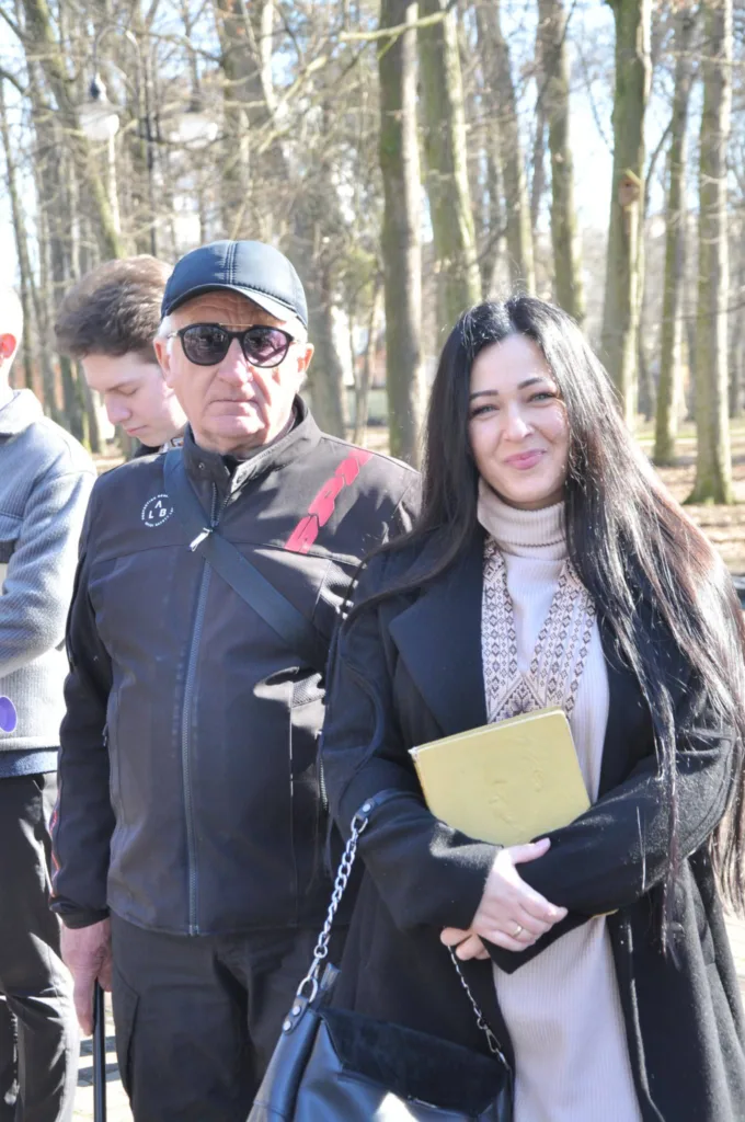 Люди стоять у парку навесні