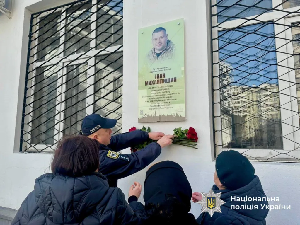 Поліцейські кладуть квіти до меморіальної дошки