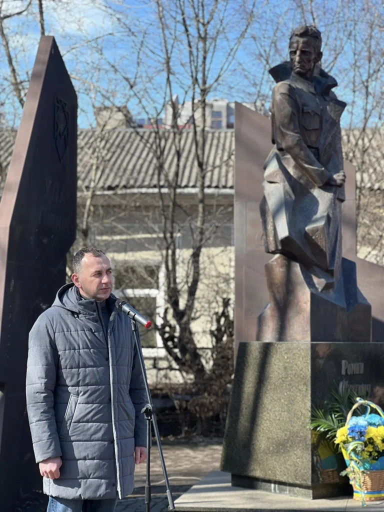 Чоловік виступає біля пам'ятника на вулиці