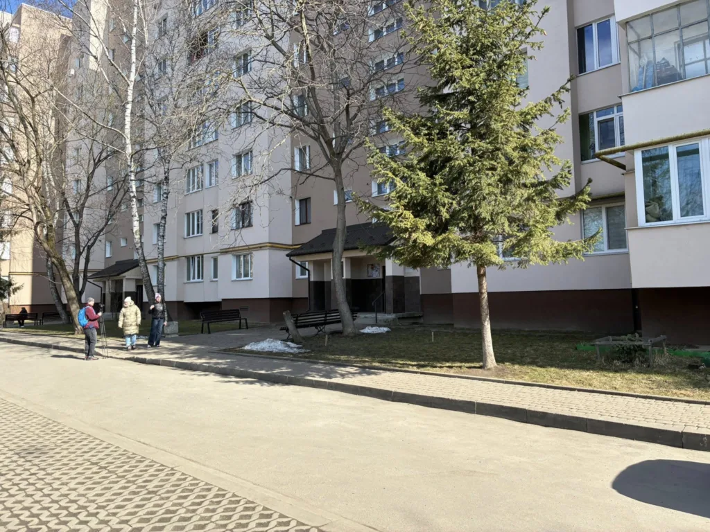 Мешканці розмовляють біля багатоповерхівки взимку