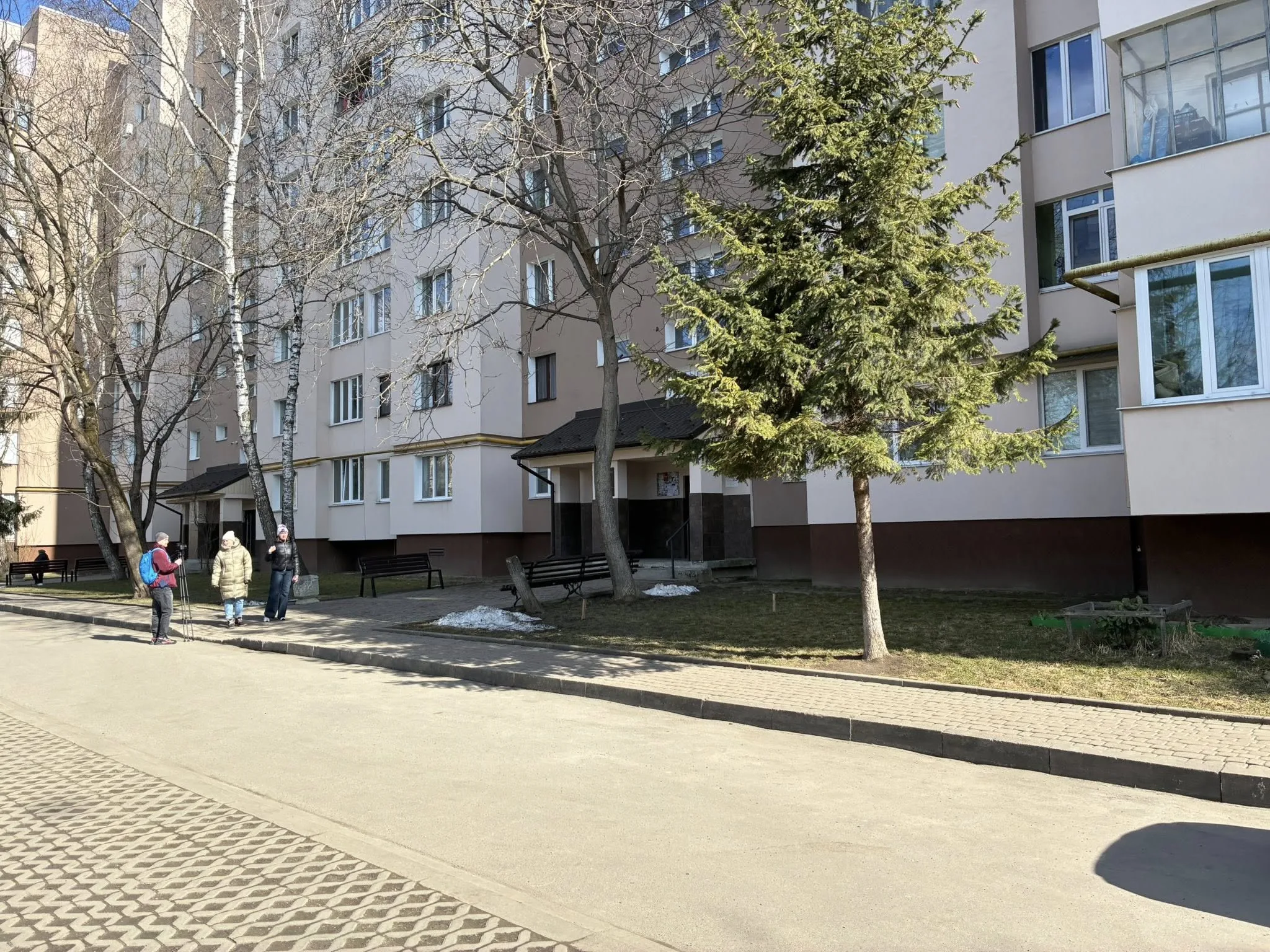 Мешканці розмовляють біля багатоповерхівки взимку