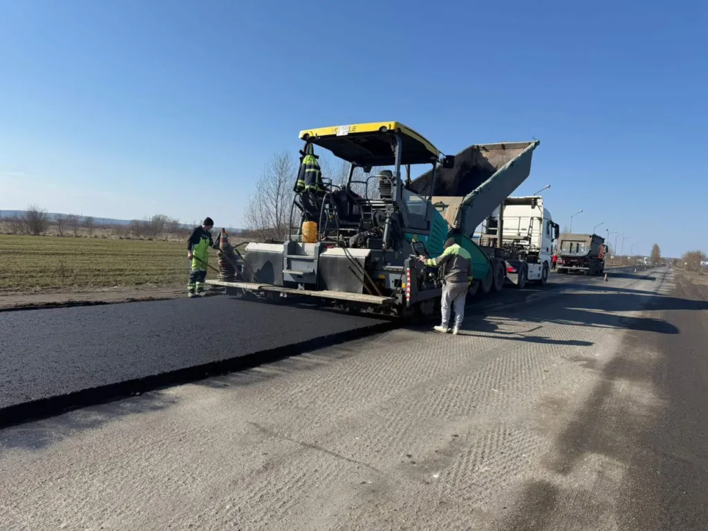 Робітники укладають новий асфальт на дорозі