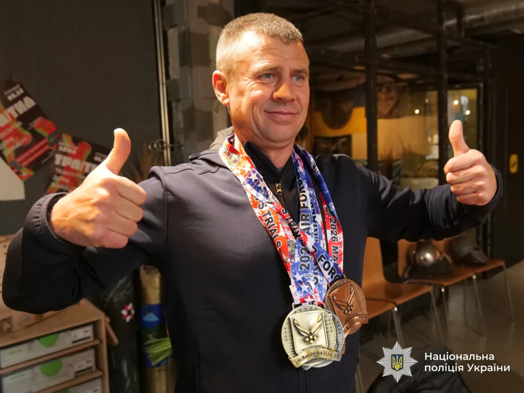 Чоловік з медалями показує великий палець вгору