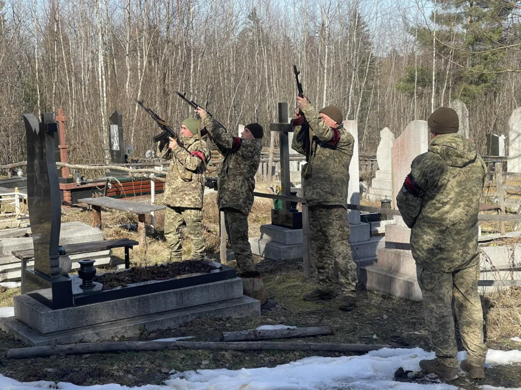 Військові віддають салют на цвинтарі