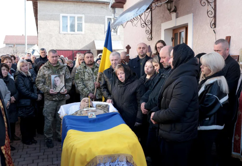 Прощання з українським військовим, накритим прапором України