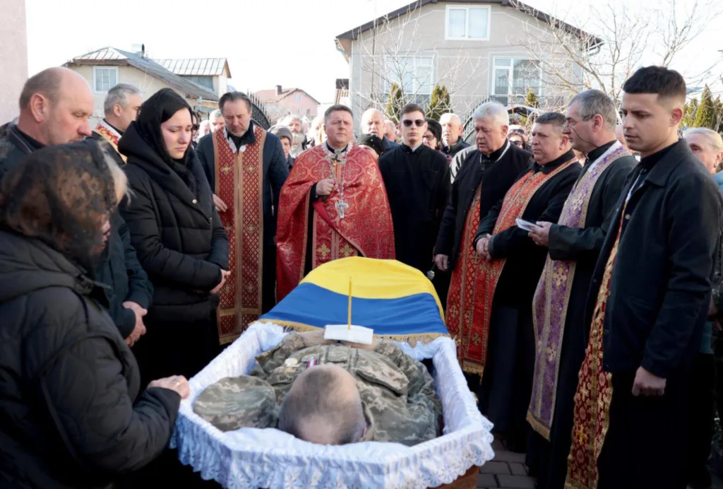 Прощання із загиблим українським військовим під прапором України