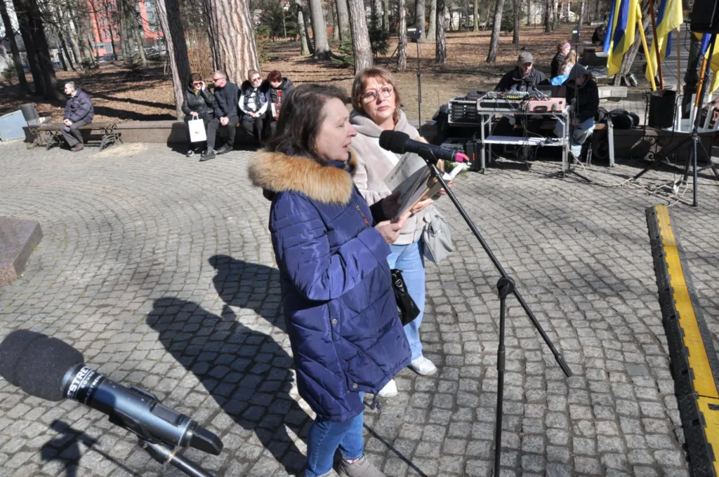 Жінки читають на мітингу у міському парку
