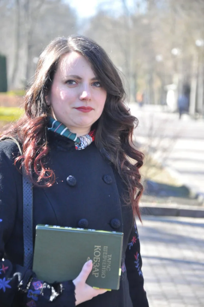 Жінка з книгою Кобзар на вулиці