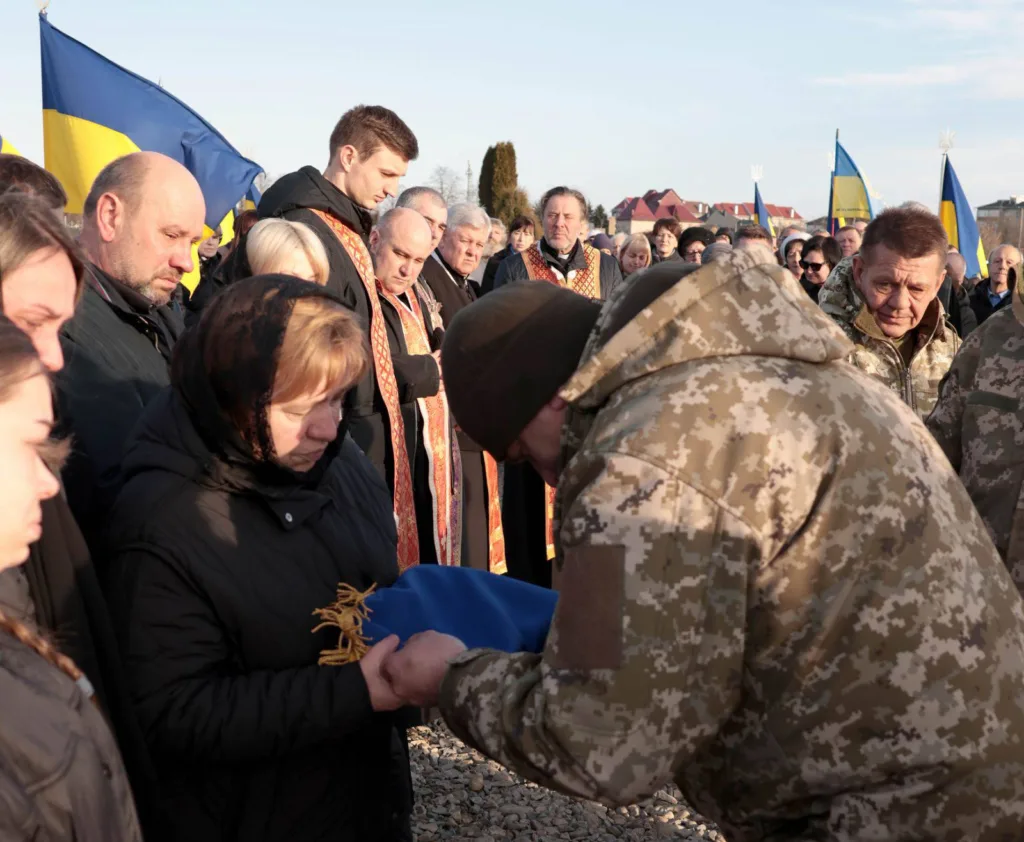 Вшанування загиблого військового з українським прапором