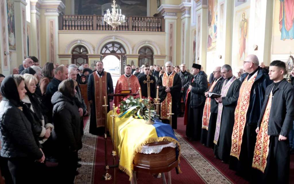 Похоронна церемонія в церкві з українським прапором