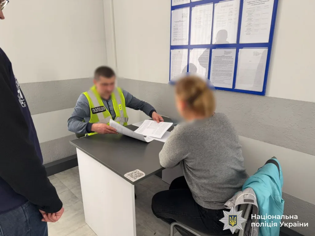 Поліцейський спілкується з жінкою у відділку поліції