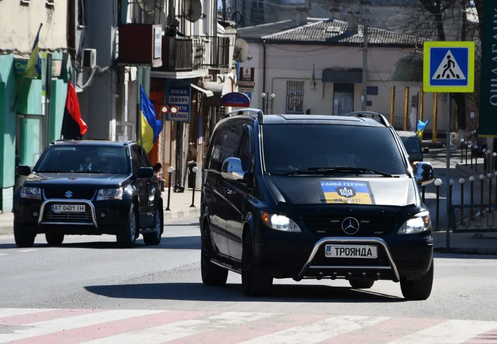 Автоколона з українськими прапорами у місті
