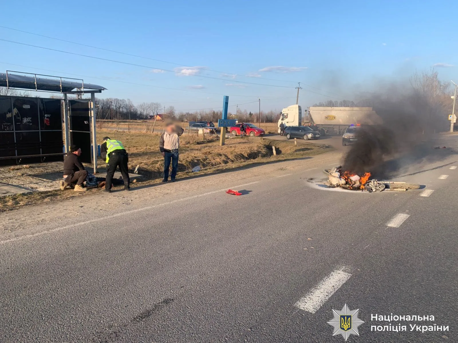 Поліція біля місця аварії та палаючого мотоцикла