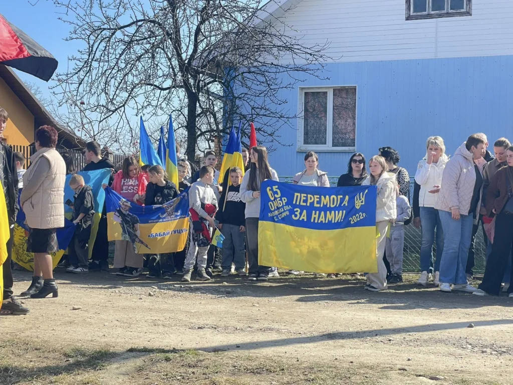 Люди з українськими прапорами на вулиці