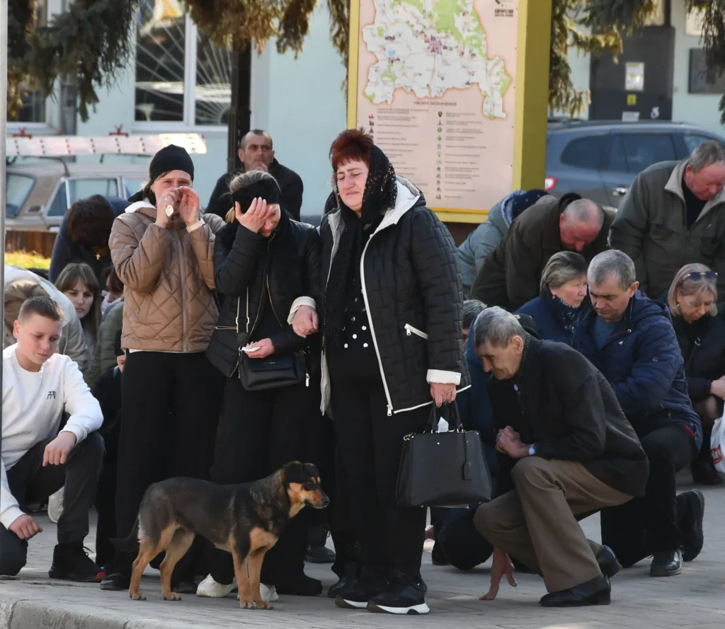 Люди сумують на вулиці поруч із собакою