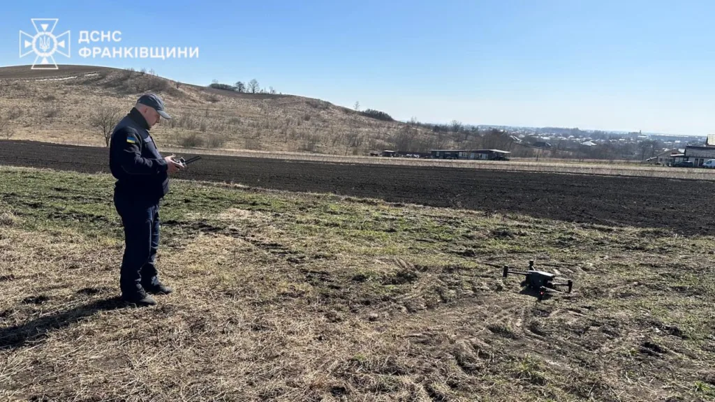 Рятувальник керує дроном на сільському полі