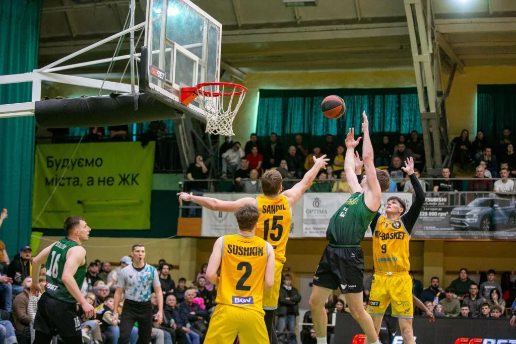 Баскетбольний матч між командами у жовтій і зеленій формі