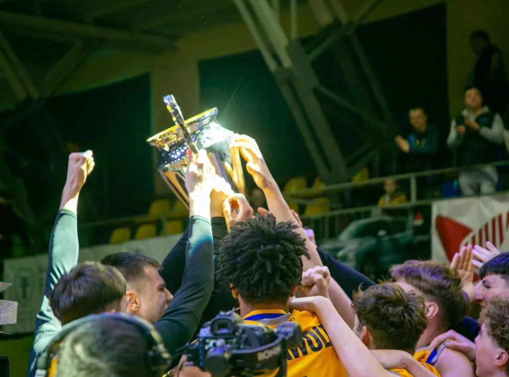 Баскетбольна команда святкує з трофеєм