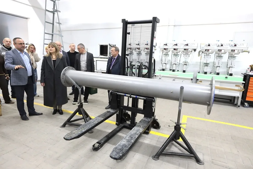 Люди оглядають промислове обладнання в лабораторії